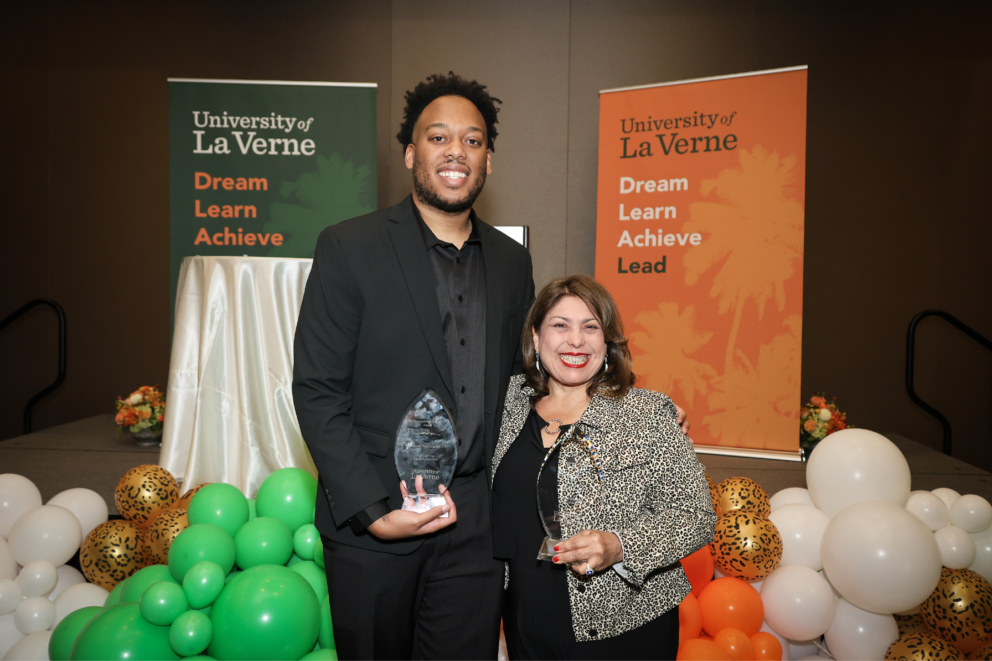 Alumni Award winners Demond Washington and Anita Ron holding their awards at the dinner celebration.