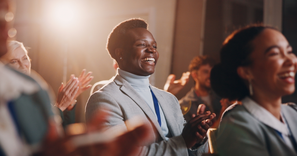 Woman clapping in a crowd.